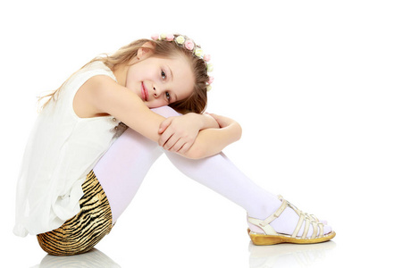 这个女孩侧身坐在地上抱着她的膝盖照片