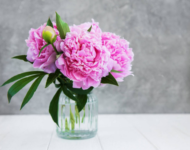 白色木桌上的粉红色牡丹花花瓶