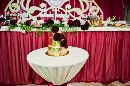 在小桌上的美味花金色婚礼蛋糕图片