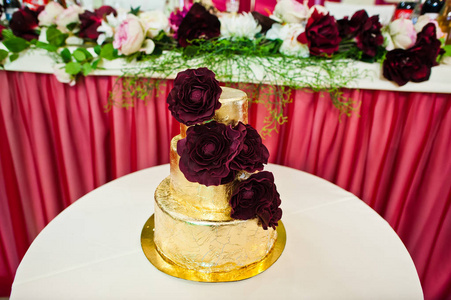 在小桌上的美味花金色婚礼蛋糕图片