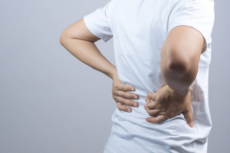 肌肉后背女人把她的双手后背或脊柱疼痛照片