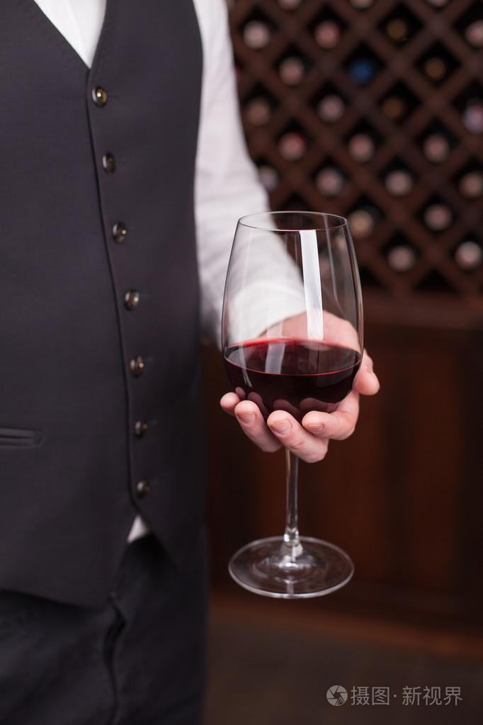 熟练的男服务员端着酒杯