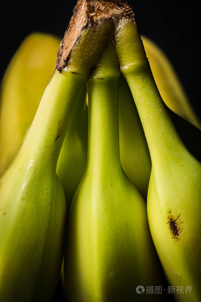 三孤立的茎为一串香蕉在黑暗的背景