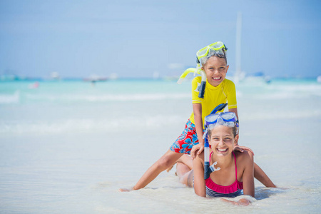 在炎热的夏日假期里, 在沙滩上玩潜水面具的兄弟姐妹