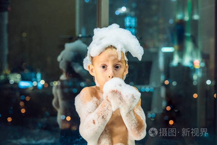 沐浴在窗前满是泡沫的婴儿的肖像