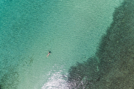 一个女孩在海里游泳的鸟瞰图