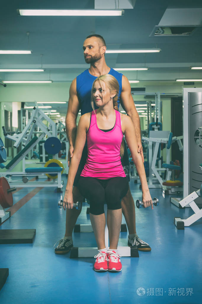 一个男人和一个女人在健身房训练