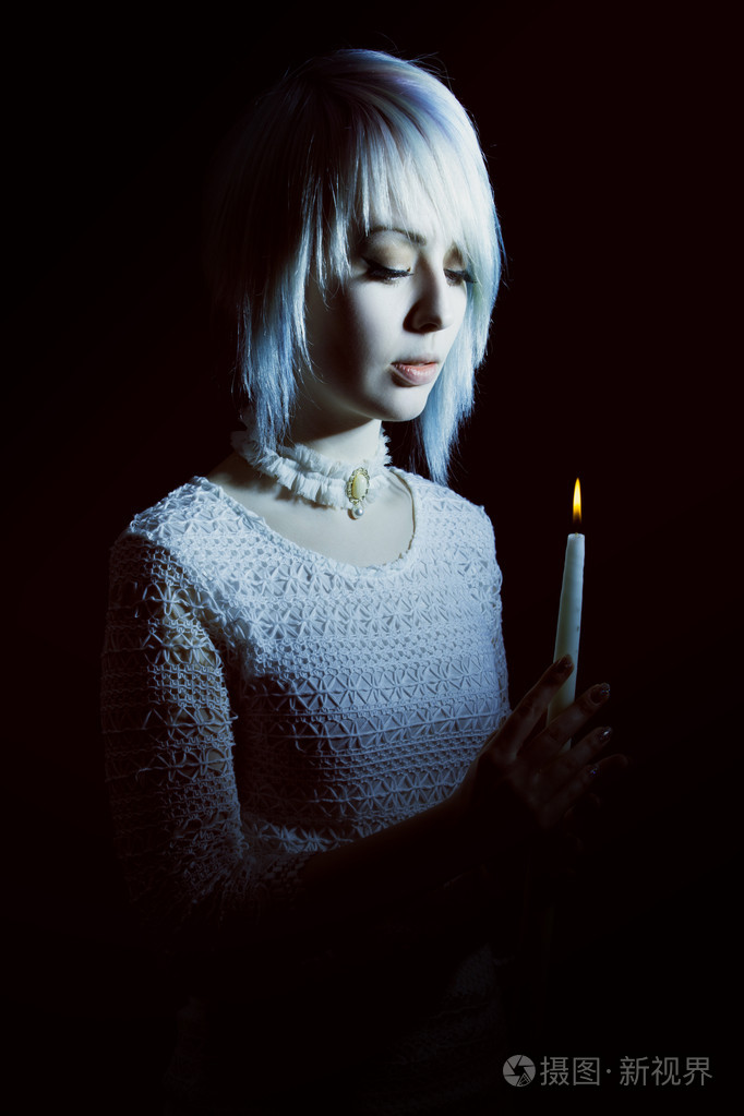 十几岁的女孩,在黑暗中与一支蜡烛,害怕她的脸上