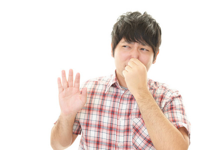 在带区和蓝色背景上隔离人用手指捏鼻子, 恶心的东西揉捏她的皮肤心烦