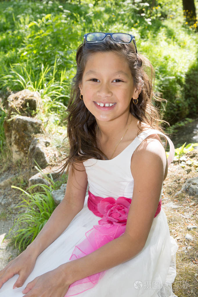 室外的混血年轻女孩的粉色和白色衣服照片-正版商用图片0oyhum-摄图新