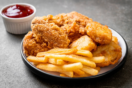 炸鸡配薯条和掘金餐垃圾食品和不健康食品照片