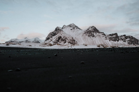 冰岛 Stokksnes 积雪覆盖的山前的黑色沙滩