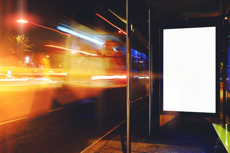 电子空白广告牌与副本空间为您的文本消息或促销内容，明确公共信息委员会在夜晚的城市与背景，公交站牌广告模拟了汽车的运动