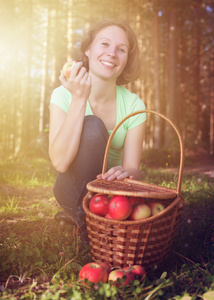 一个漂亮的女人带着一篮子苹果。