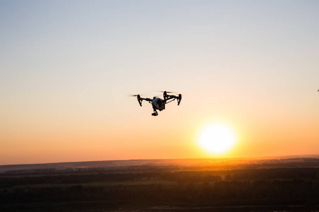 无人机的剪影, quadrocopter 与相片照相机在天空飞行照片