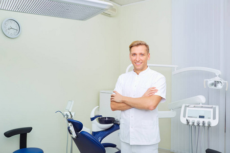 一个牙医人肖像站立在工作场所在牙科