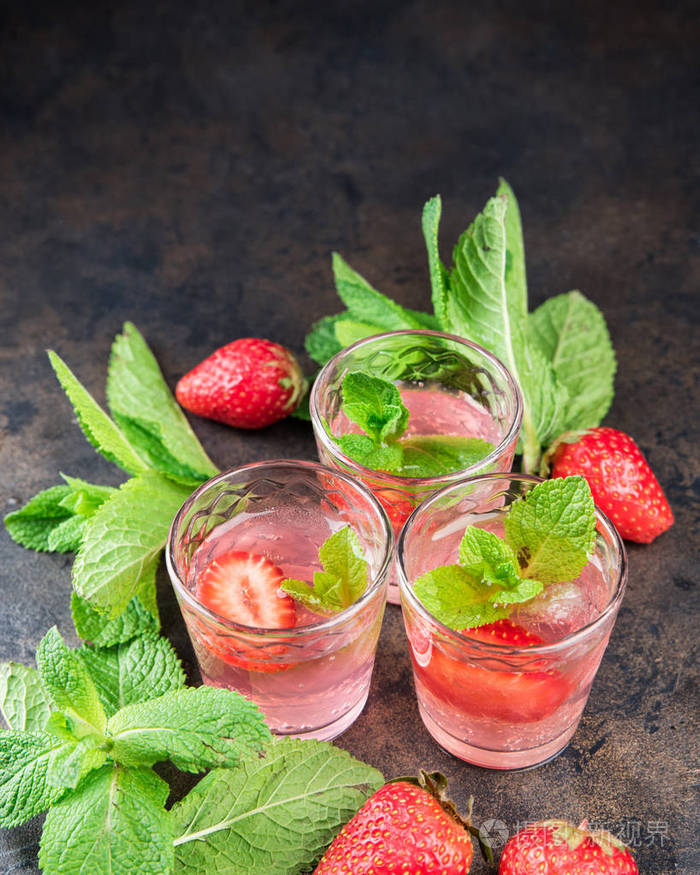 自制的草莓甜酒在金属桌上酒杯中的酒精水果鸡尾酒镜头