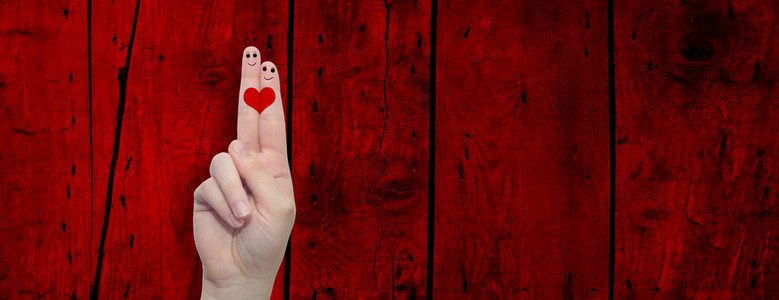 两只手的手指与红色木材图案复古背景横幅中画了一颗心