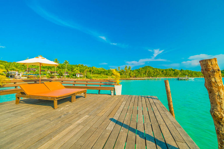 在美丽的热带海滩和海洋与椰子棕榈树在天堂岛的旅行和假期的雨伞和椅子