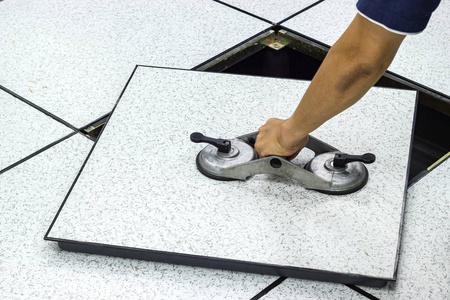 工业吸盘工具平台上的手持式吸盘-在服务器房内的开放式地板瓦提升机