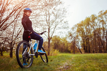 春天森林里骑自行车的年轻女子。Helathy 生活方式概念