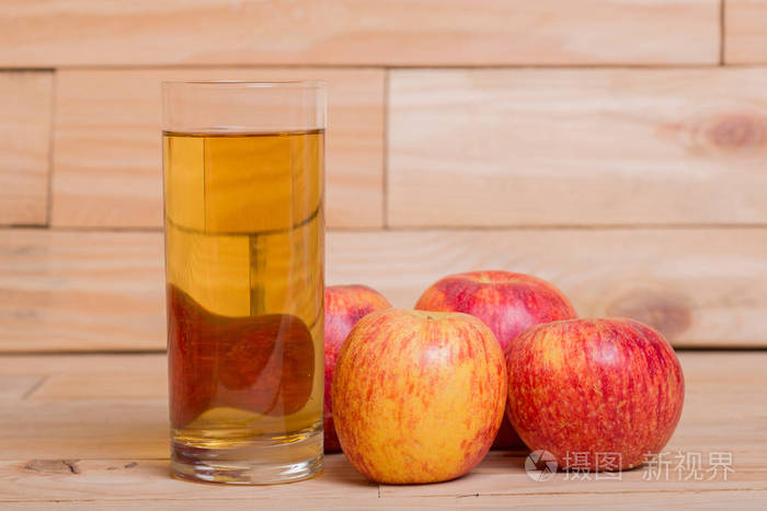 杯苹果汁和木制背景下的红苹果