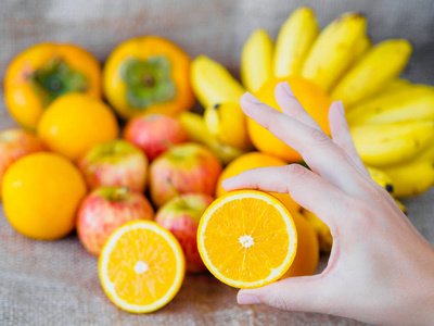 手中拿着橙色水果上背景苹果桔子香蕉李子