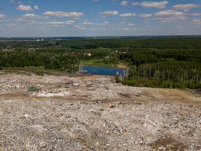 环境污染。空中顶部的照片从飞行无人驾驶的大垃圾堆。垃圾堆在树上小湖附近的垃圾堆或堆填区。卡车倾倒