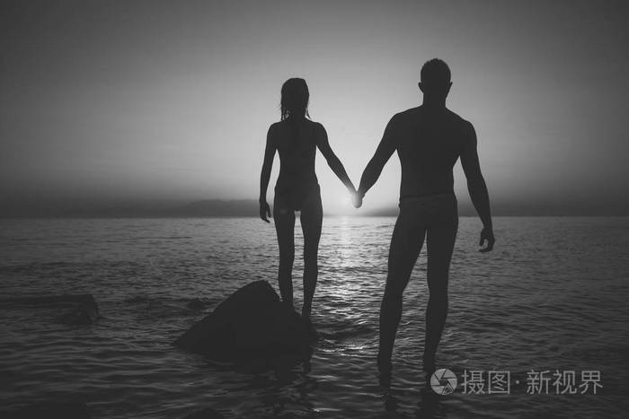 情侣相爱的浪漫约会在傍晚牵手在海边.浪漫与爱情概念