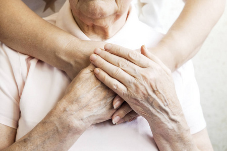 老年护理机构的成熟女性得到医院人事护士的帮助。老年妇女, 年龄皱纹的皮肤和她的照顾送礼者的手。伟大的母亲每天的生活。背景, 复制