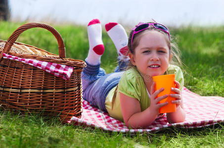 带野餐篮和塑料杯的小女孩