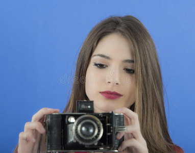 年轻漂亮的女人拿着一个老式照相机