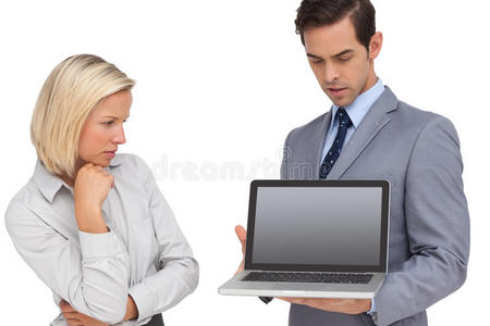 女商人看着同事拿着的笔记本电脑