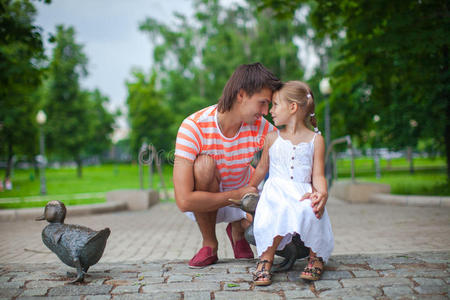 年轻快乐的父亲带着女儿在公园里