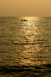 夕阳下的海上独木舟剪影