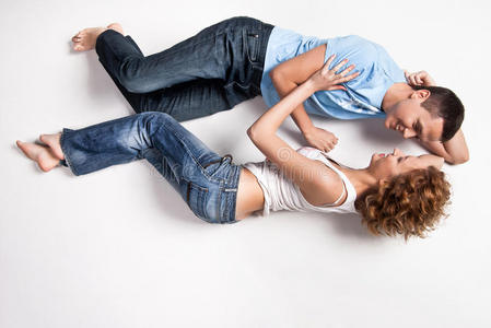 一对幸福的年轻夫妇躺在地板上的画像