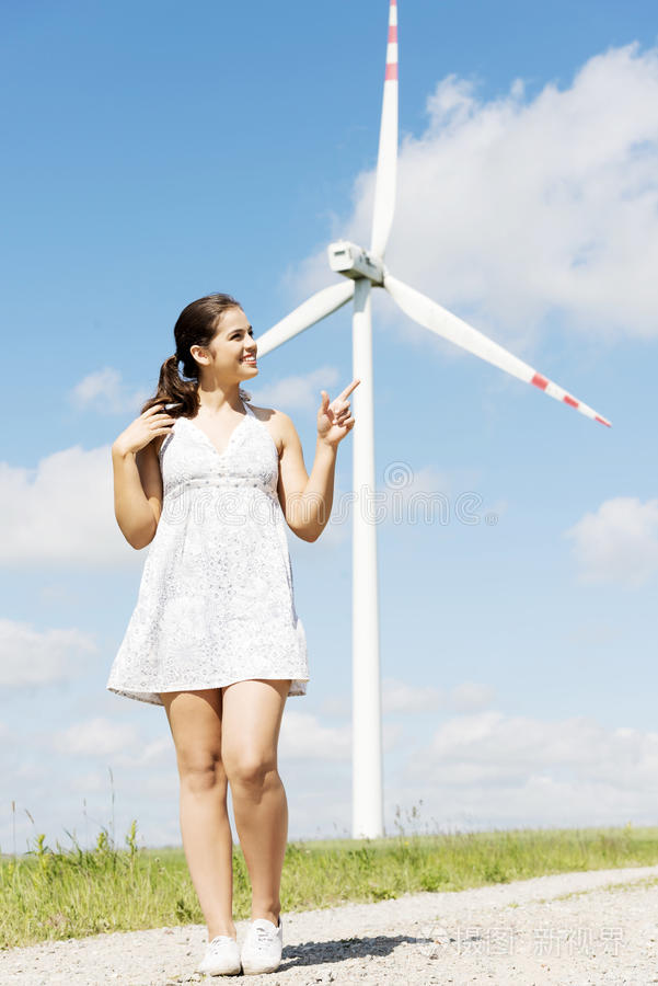 风力发电机旁边的少女。