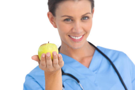 快乐的外科医生拿着苹果微笑着
