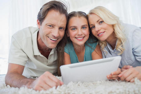 一个女孩和她父母使用平板电脑的肖像