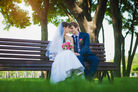 新郎新娘坐在长凳上