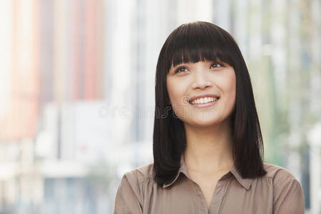 北京户外微笑年轻女子的画像，抬头