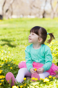 小女孩坐在花丛中的空地上图片