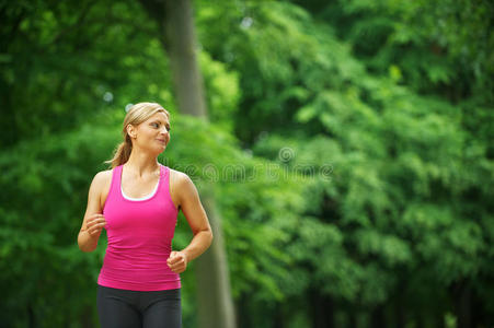 一个年轻女子独自在公园里跑步