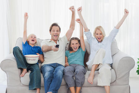 家人看电视和举起手臂