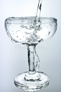 显示出一种饮料的概念从厨房水龙头往杯子里倒水