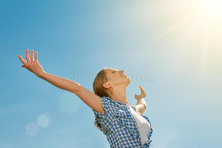快乐的年轻女子向天空张开双臂