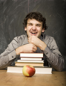 教室里拿着书和红苹果的年轻情感学生