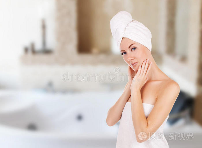 浴室里拿毛巾的女人和按摩浴缸