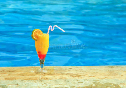 一杯果汁在游泳池的边缘