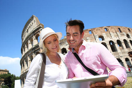 阳光明媚的日子里，一对幸福的夫妇在罗马看平板电脑